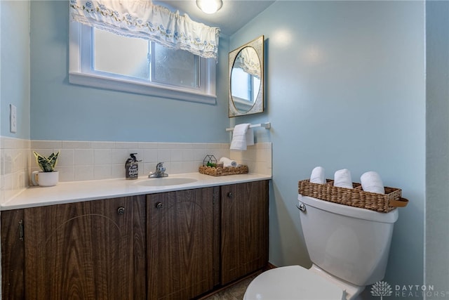 bathroom with vanity, decorative backsplash, and toilet