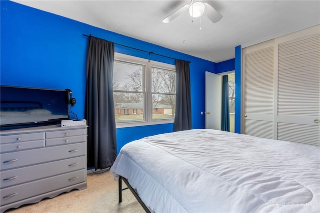 bedroom with light colored carpet, a closet, and ceiling fan