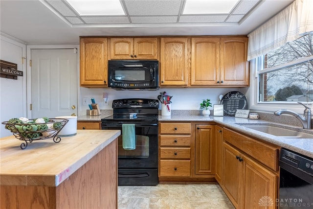 kitchen with a paneled ceiling, wooden counters, sink, and black appliances