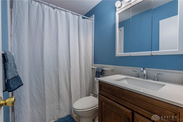 bathroom with vanity, tile walls, and toilet