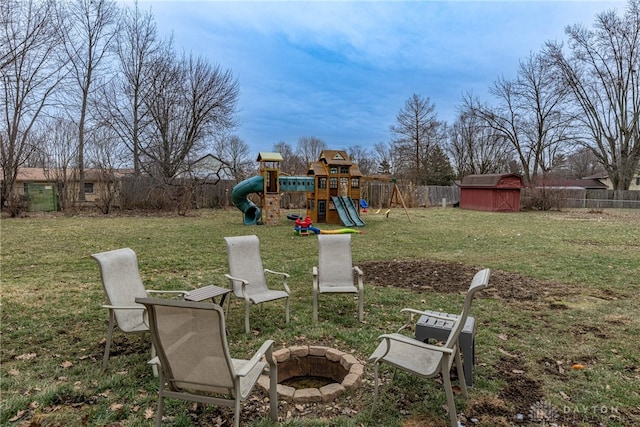 view of yard featuring a playground, a storage unit, and an outdoor fire pit