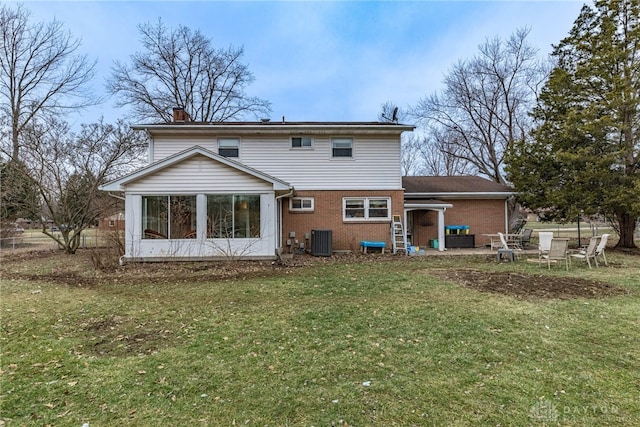 rear view of house with central AC and a lawn