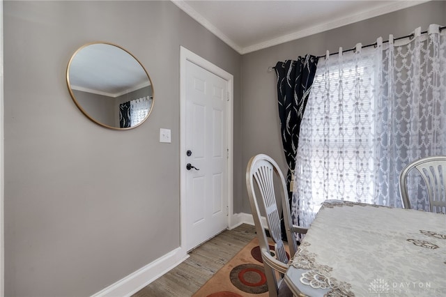 dining room with baseboards, wood finished floors, and crown molding