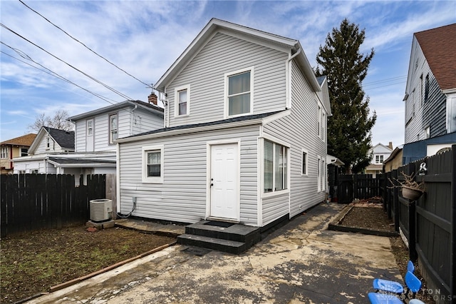 back of property with entry steps, cooling unit, and a fenced backyard