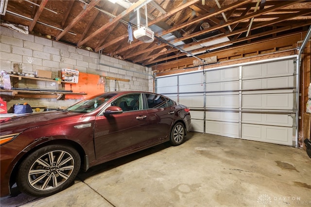 garage with concrete block wall and a garage door opener