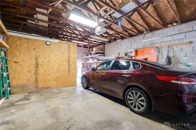 garage featuring concrete block wall and a garage door opener