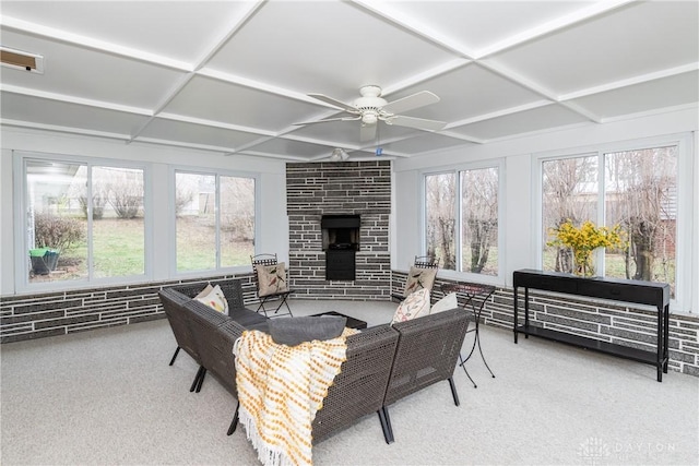 sunroom / solarium with coffered ceiling, a large fireplace, and ceiling fan