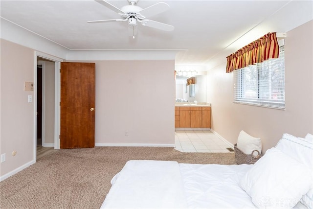 carpeted bedroom with ceiling fan, ensuite bath, and sink