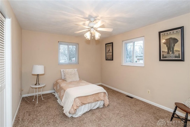 bedroom with multiple windows, ceiling fan, and carpet flooring