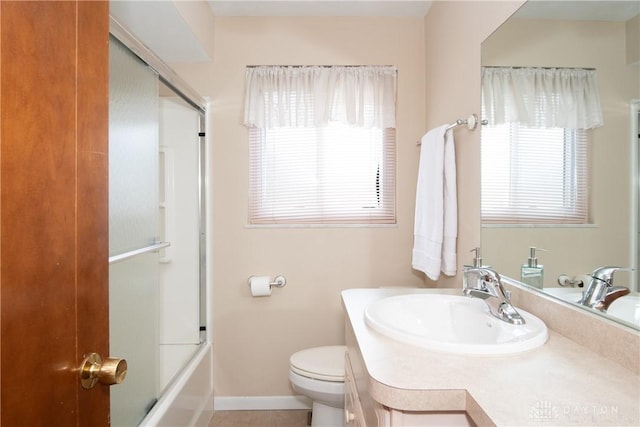 full bathroom featuring vanity, shower / bath combination with glass door, and toilet