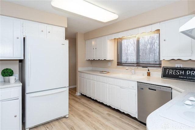 kitchen featuring white cabinetry, sink, white refrigerator, stainless steel dishwasher, and light hardwood / wood-style floors