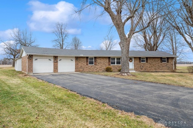 ranch-style house with a garage and a front lawn