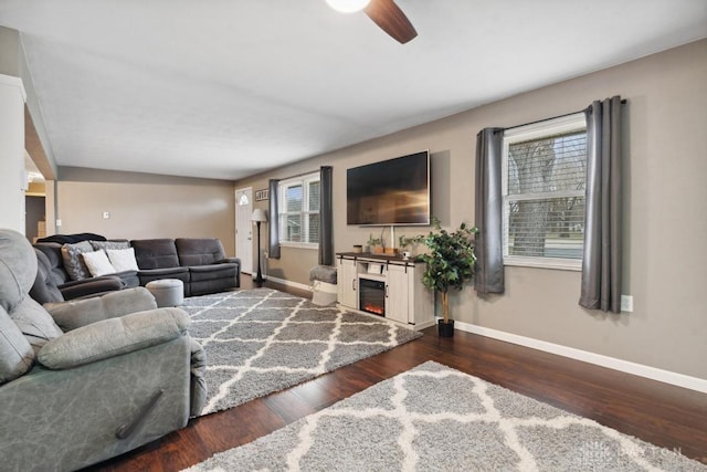 living room featuring ceiling fan and dark hardwood / wood-style flooring