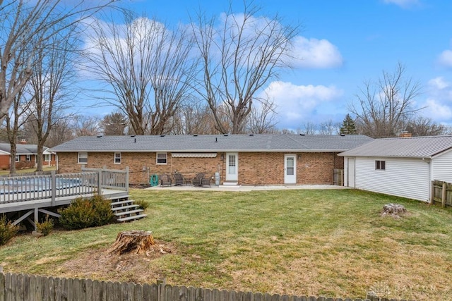 back of house featuring a yard, a deck, and a patio