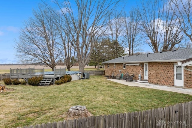 view of yard featuring a wooden deck, cooling unit, and a patio area