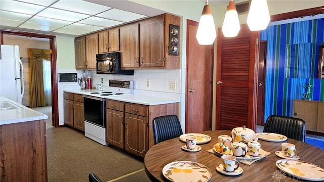 kitchen with white appliances, decorative light fixtures, sink, and decorative backsplash