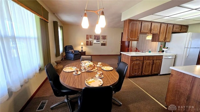 carpeted dining area with sink