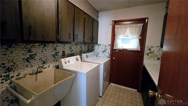 washroom with cabinets, sink, and washer and clothes dryer