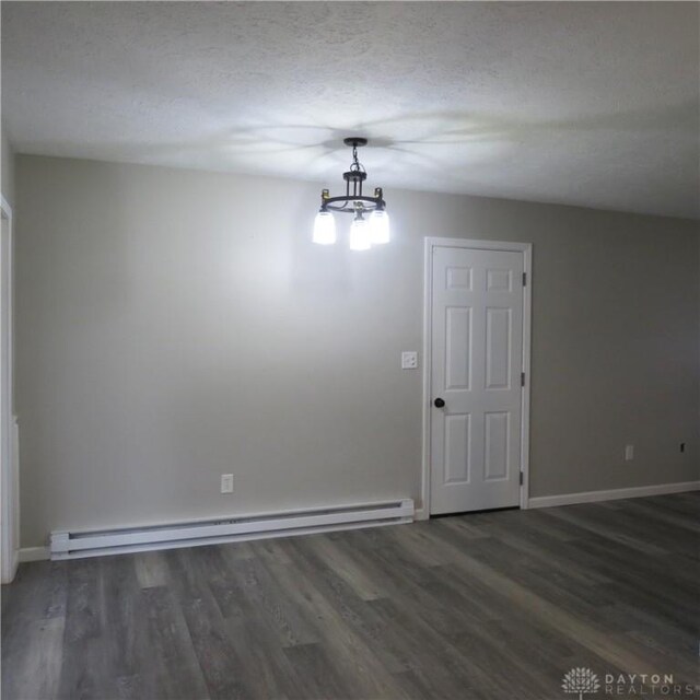 1148 Hamilton, Sidney, OH 45365 - spare room featuring a baseboard heating unit, a textured ceiling, a notable chandelier, and dark hardwood / wood-style flooring