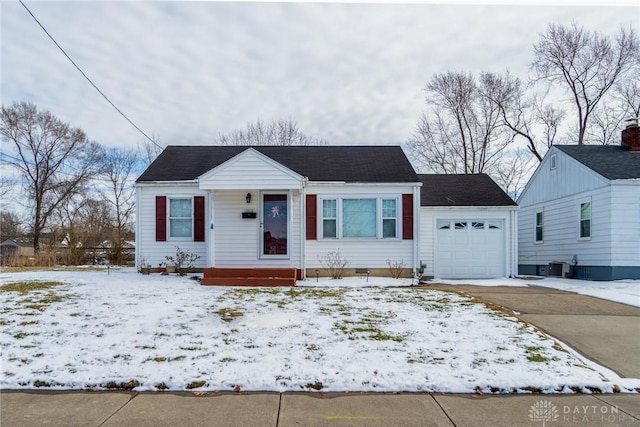 view of front of property with driveway, a garage, and central AC