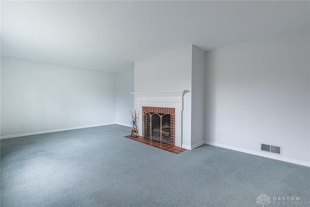 unfurnished living room featuring dark carpet and a brick fireplace