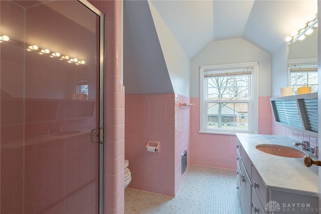 bathroom with lofted ceiling, tile walls, tile patterned flooring, vanity, and an enclosed shower