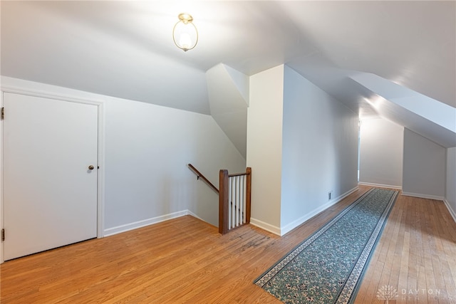 bonus room with vaulted ceiling and light hardwood / wood-style floors