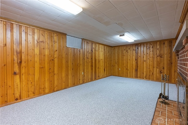 basement featuring carpet and wooden walls