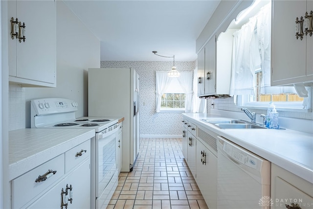 kitchen with sink, white cabinets, and white appliances