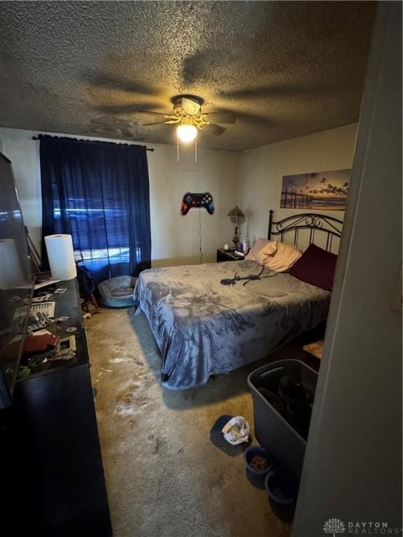 bedroom with concrete flooring, ceiling fan, and a textured ceiling