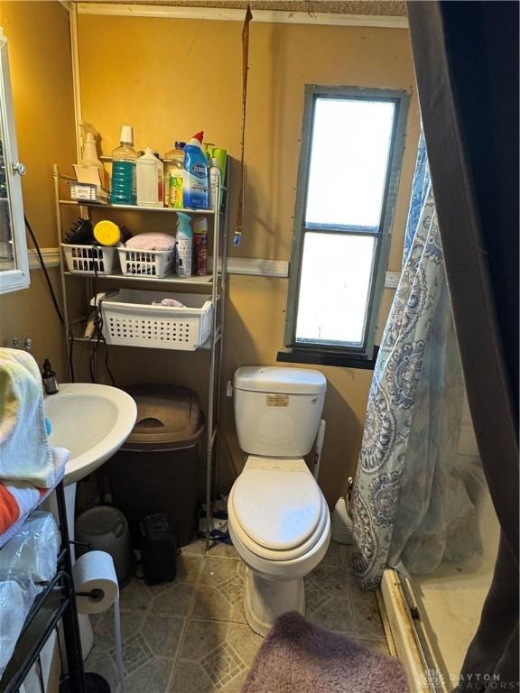 bathroom featuring tile patterned flooring, walk in shower, and toilet