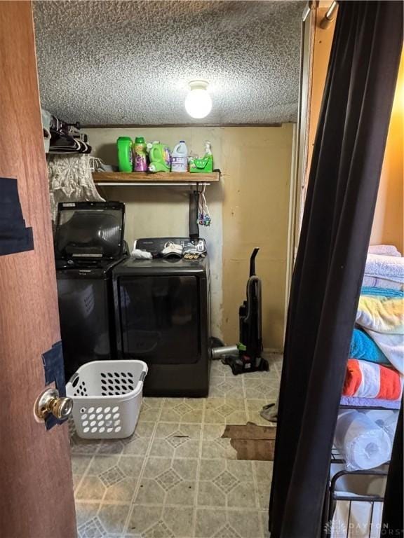 laundry room with separate washer and dryer and a textured ceiling