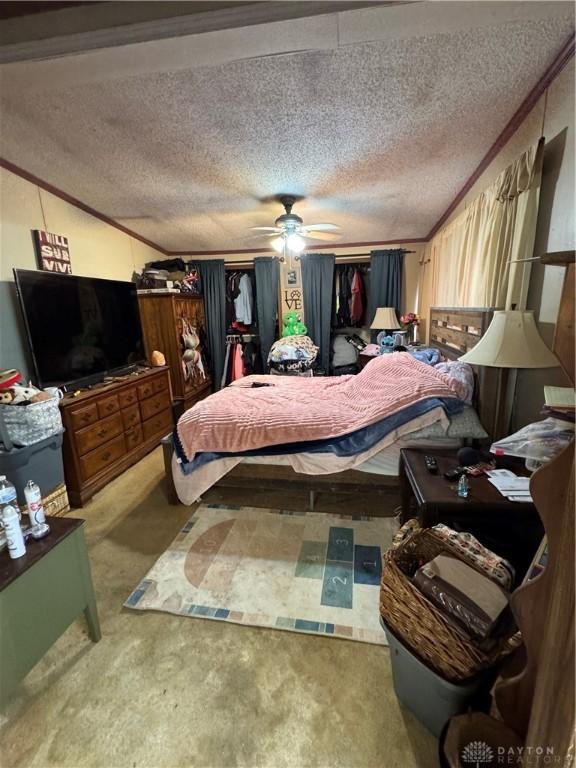 bedroom with crown molding, carpet floors, and a textured ceiling