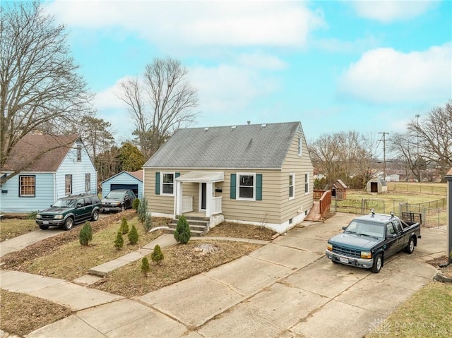 bungalow-style house featuring driveway, roof with shingles, and fence