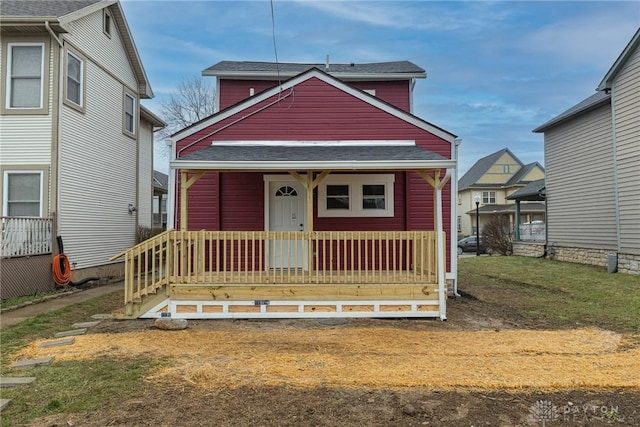 view of front of home with covered porch and a front lawn