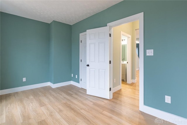 unfurnished bedroom featuring a textured ceiling and light wood-type flooring