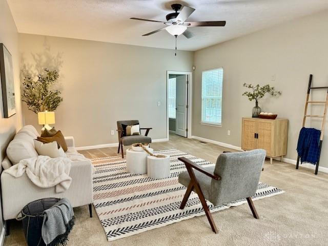 carpeted living room with ceiling fan