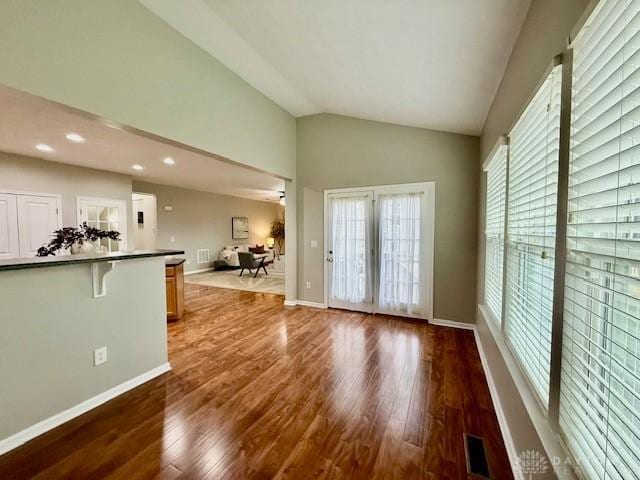 unfurnished living room featuring dark wood-type flooring and lofted ceiling