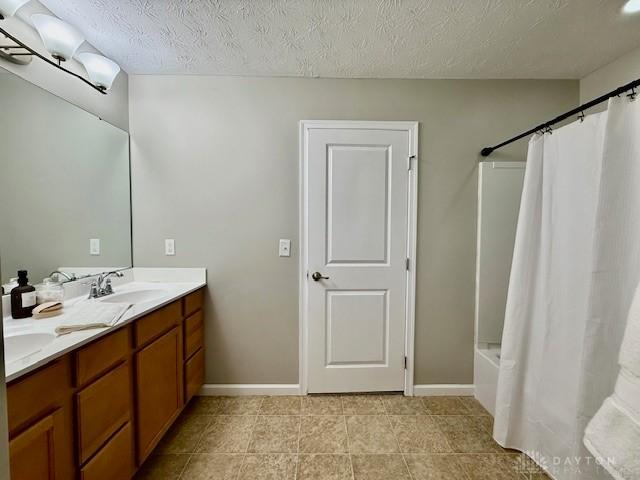 bathroom featuring tile patterned floors, vanity, a textured ceiling, and shower / bath combo