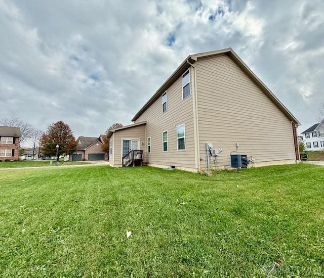 view of property exterior with central AC and a yard