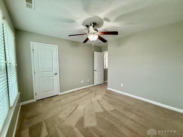 unfurnished bedroom featuring carpet and ceiling fan