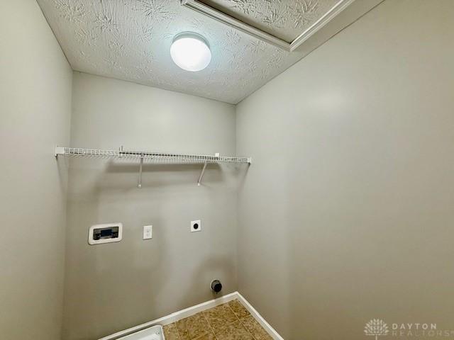 washroom with hookup for a washing machine, hookup for an electric dryer, and a textured ceiling