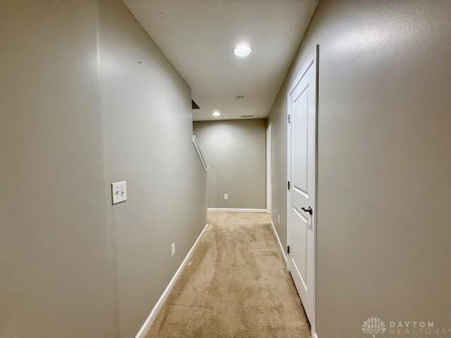 hallway featuring light colored carpet