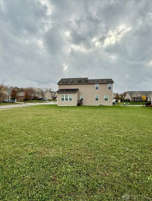 back of property featuring a lawn