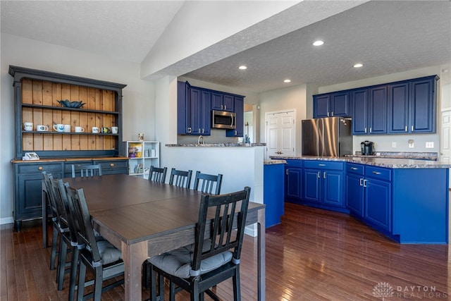 dining area featuring a textured ceiling, baseboards, dark wood finished floors, and recessed lighting