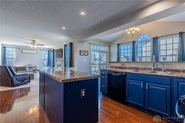 kitchen featuring black dishwasher, open floor plan, a center island, blue cabinets, and a sink