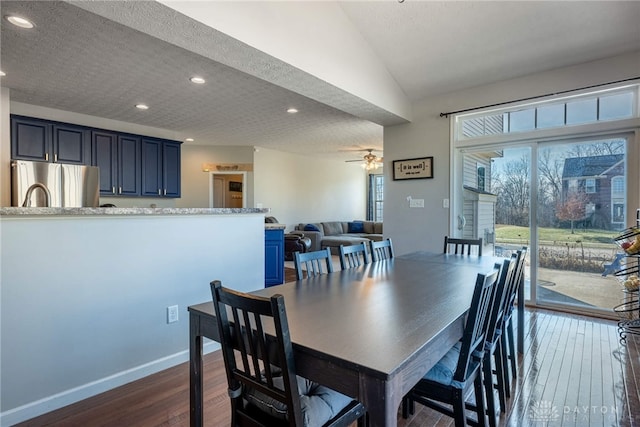 dining area with a textured ceiling, lofted ceiling, recessed lighting, baseboards, and dark wood-style floors