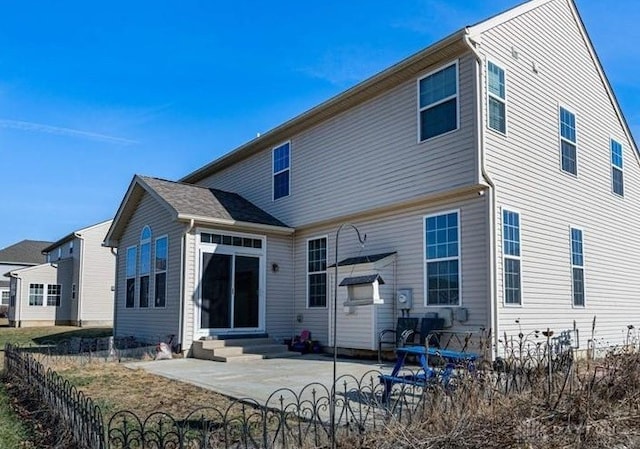 rear view of property with entry steps and a patio