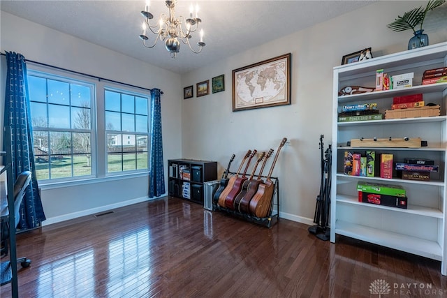 living area featuring a notable chandelier, dark wood finished floors, visible vents, and baseboards