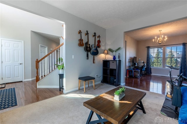 carpeted living room featuring a chandelier, a textured ceiling, baseboards, and stairs